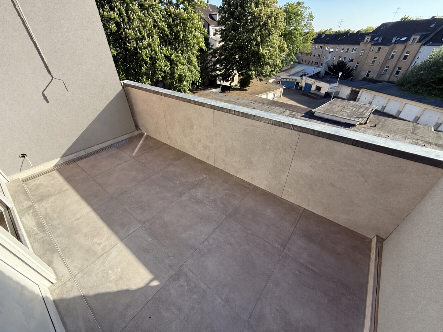 Balkon mit großformatigen Bodenfliesen und gefliester Brüstung; Wandgestaltung digital verändert